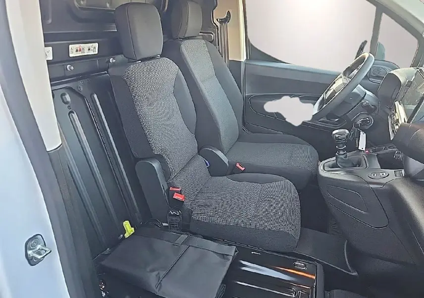 Vue intérieure côté conducteur du Citroën Berlingo Fourgon blanc 2026, montrant les sièges avant et le volant multifonction.