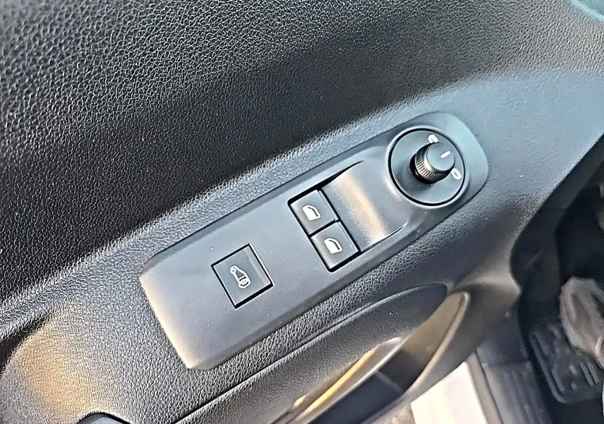 Gros plan sur le panneau de commande des vitres et rétroviseurs côté conducteur du Citroën Berlingo Fourgon blanc.