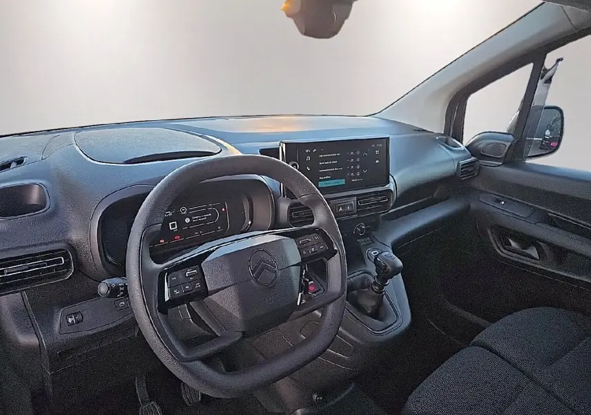 Intérieur du Citroën Berlingo Fourgon blanc, vue côté conducteur, volant multifonction et écran tactile central visibles.
