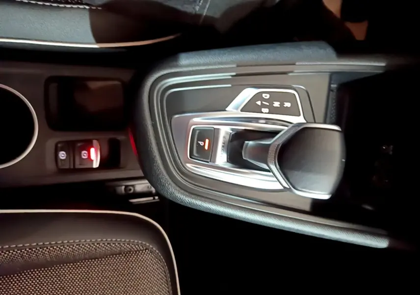 Gros plan sur la console centrale noire du Renault Captur Intens E-Tech 2021, montrant le levier de vitesse automatique et frein à main électrique.