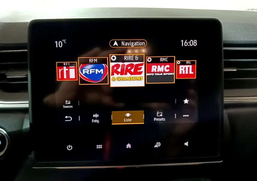 Écran tactile central du tableau de bord du Renault Captur gris clair, affichant les stations radio en mode navigation.