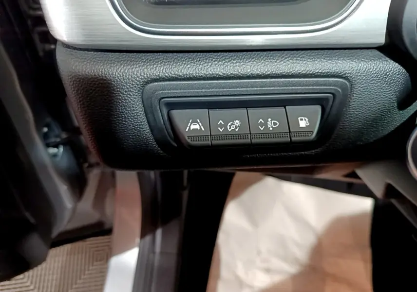 Vue intérieure du tableau de bord côté gauche du Renault Captur gris clair, avec boutons de réglage des aides à la conduite.