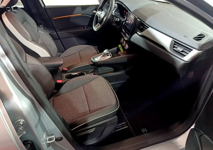 Vue intérieure côté conducteur du Renault Captur gris clair 2021 avec tableau de bord moderne et sièges tissu gris.