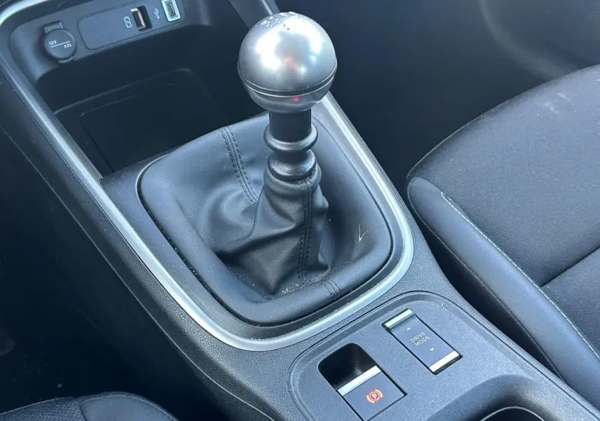 Gros plan sur la commande de boîte manuelle et l'accoudoir central du Jeep Avenger gris, version 2025.