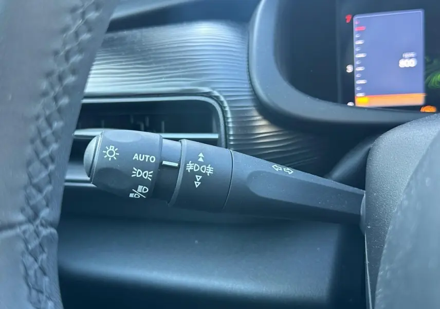 Gros plan sur la commande d'éclairage à gauche du volant dans l'habitacle du Jeep Avenger gris 2025.