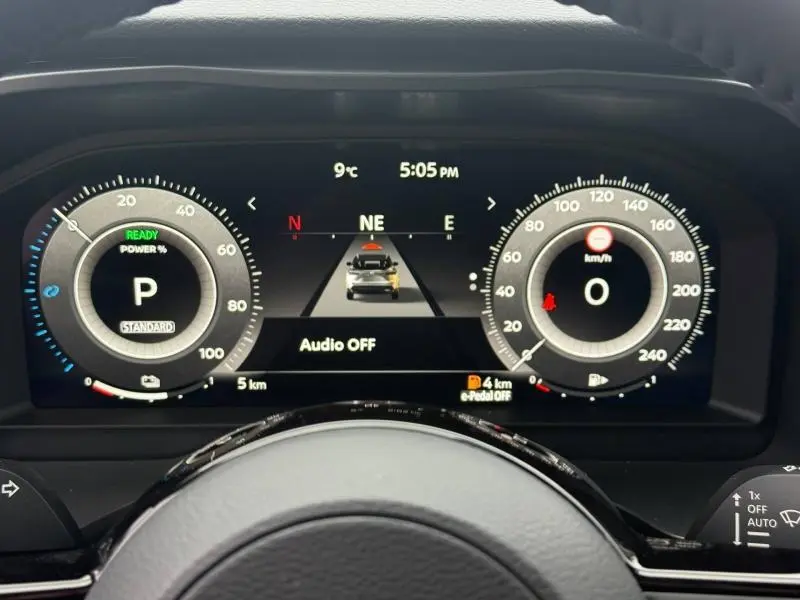 Tableau de bord numérique du Nissan Qashqai Hybrid e-POWER 2025, affichage vitesse et autonomie, vue frontale depuis le volant.