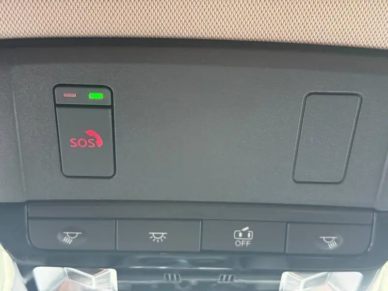 Vue rapprochée des boutons de commande au plafond intérieur du Nissan Qashqai Hybrid e-POWER 2025, avec bouton SOS rouge et indicateur vert.