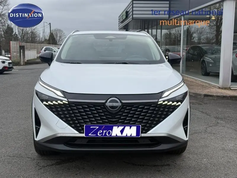 Vue avant d'un Nissan Qashqai Hybrid e-POWER blanc nacré avec calandre noire texturée et feux LED distinctifs.