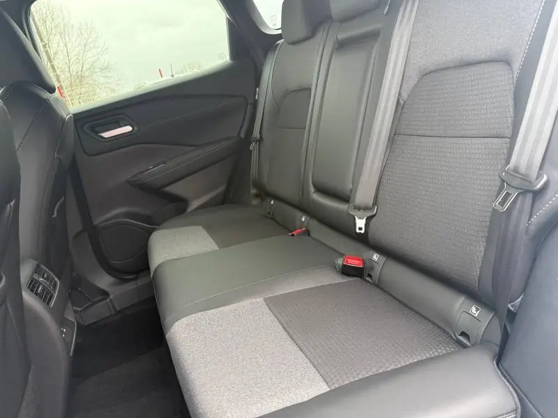 Vue intérieure côté droit des sièges arrière en tissu noir et gris du Nissan Qashqai Hybrid e-POWER 2025.