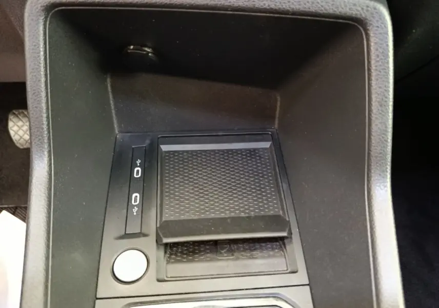 Gros plan sur la console centrale noire du Volkswagen Caddy 2.0 TDI 122ch, avec ports USB et surface antidérapante.