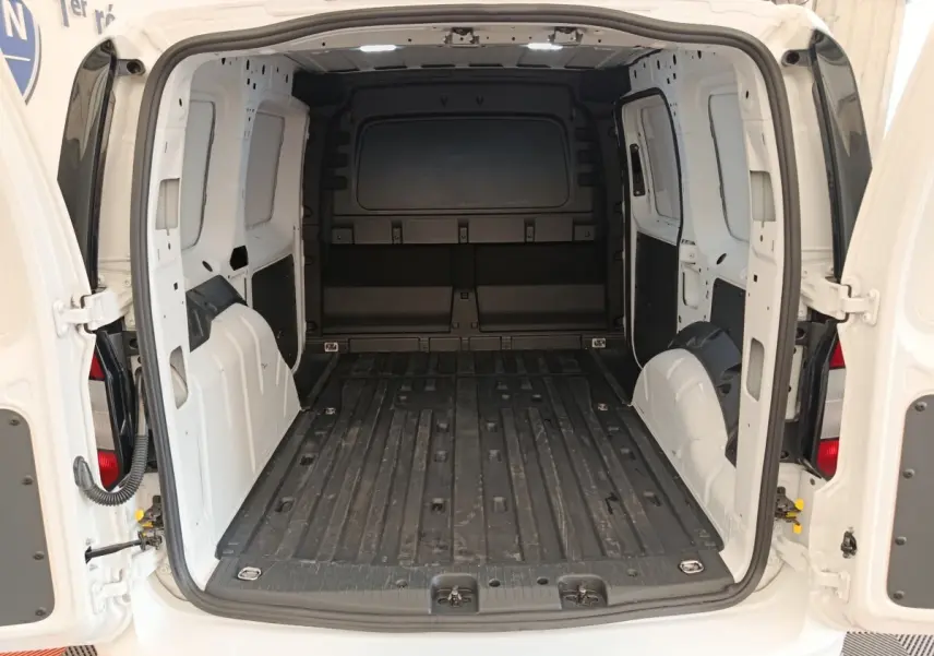 Vue arrière du Volkswagen Caddy blanc 2022 montrant l'espace de chargement vide et les portes battantes ouvertes.
