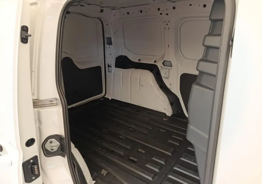 Vue intérieure arrière du coffre blanc du Volkswagen Caddy 2.0 TDI 122ch avec plancher noir et parois métalliques.