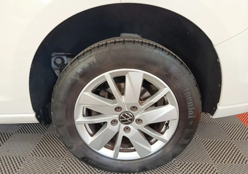 Gros plan sur la roue avant droite blanche d’un Volkswagen Caddy 2.0 TDI 122ch avec jante en alliage et pneu Continental.