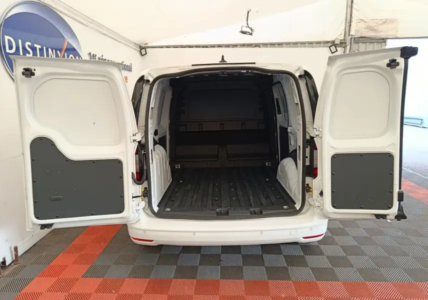 Vue arrière du Volkswagen Caddy blanc 2022 avec portes arrière ouvertes montrant l'espace de chargement vide.