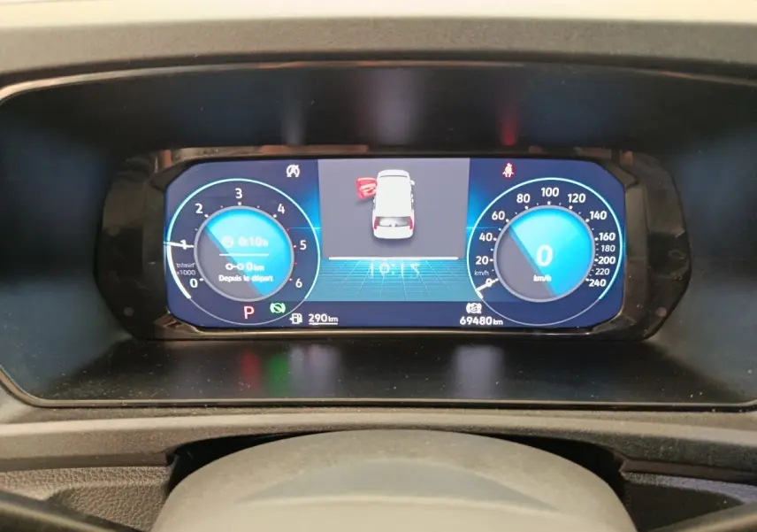Vue rapprochée du tableau de bord numérique du Volkswagen Caddy 2022 affichant la vitesse et les alertes.