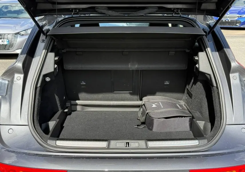 Coffre ouvert vu de l'arrière d'un DS7 E-TENSE gris titane avec sac de rangement noir à l'intérieur.