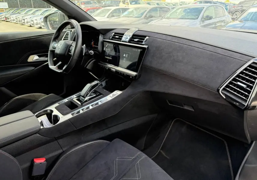 Vue intérieure côté conducteur du DS7 E-TENSE 2024, montrant la planche de bord et la console centrale en Alcantara noir.