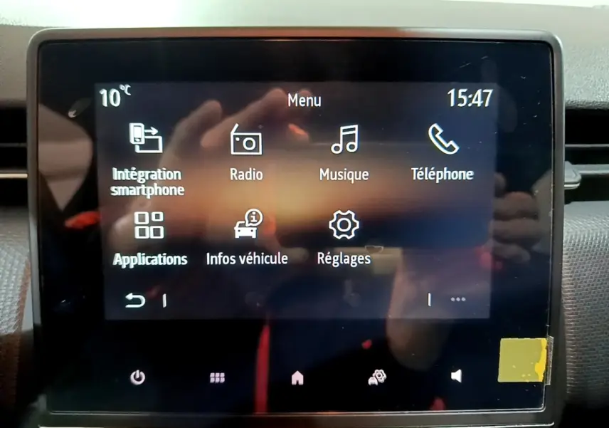 Écran tactile central de la Renault Clio 2023 affichant le menu principal avec options smartphone, radio et réglages.