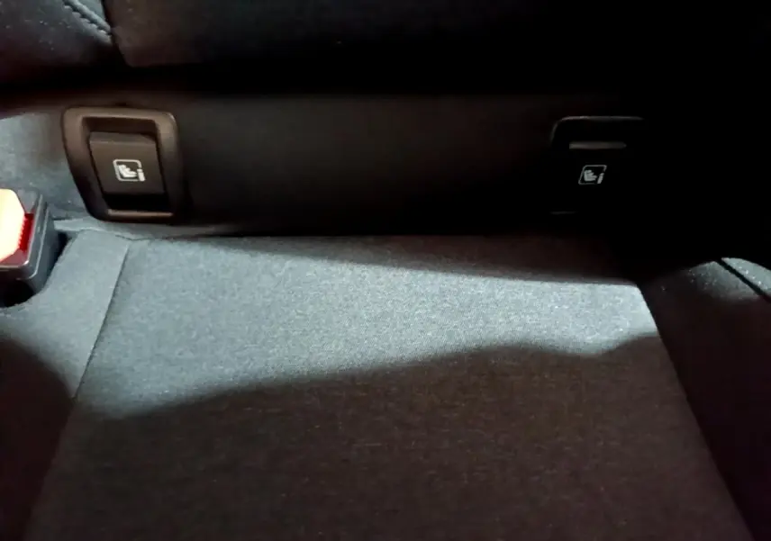 Détail du plancher arrière avec commandes de rabattement des sièges sur Renault Clio gris clair 2023.