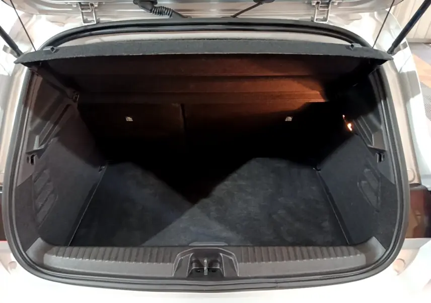 Coffre ouvert vu de l'arrière d'une Renault Clio gris clair 2023, espace de chargement vide et propre.