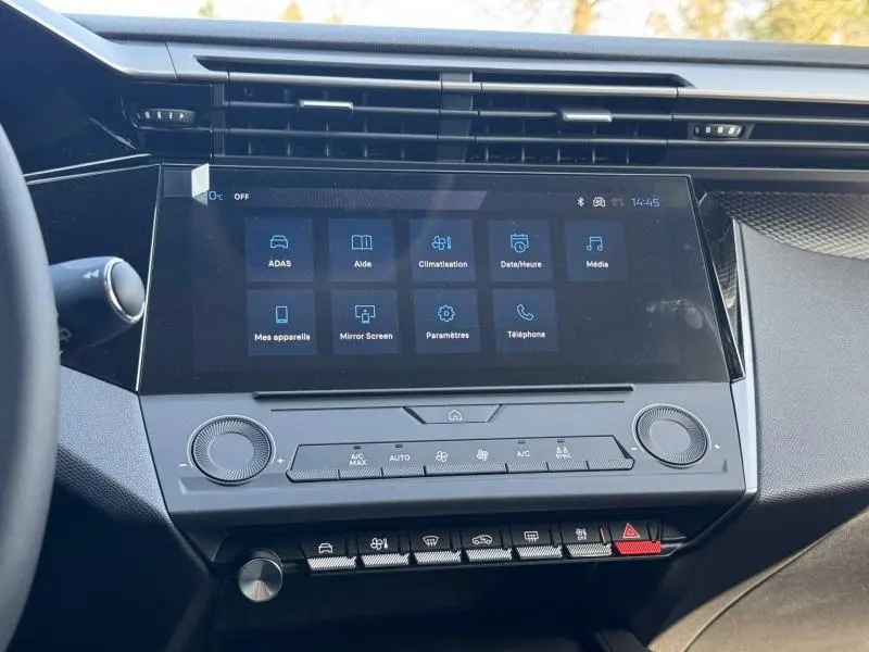 Vue rapprochée de l’écran tactile central et des commandes de climatisation de la Peugeot 308 2025 blanc Okénite.