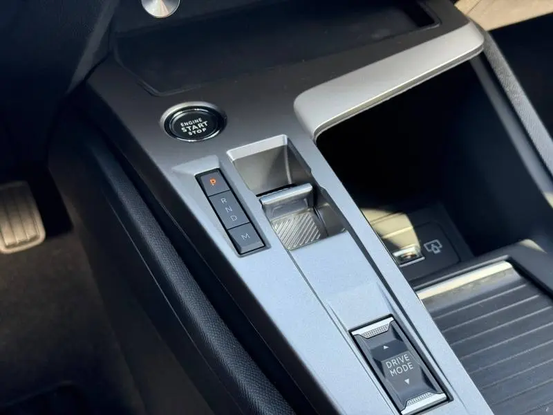 Gros plan sur la console centrale grise de la Peugeot 308 2025, avec bouton start/stop et commandes de boîte automatique.