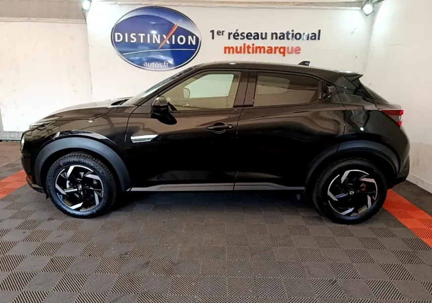Vue de profil côté gauche d'un Nissan Juke DIG-T 114 DCT noir avec jantes noires et détails de carrosserie marqués.