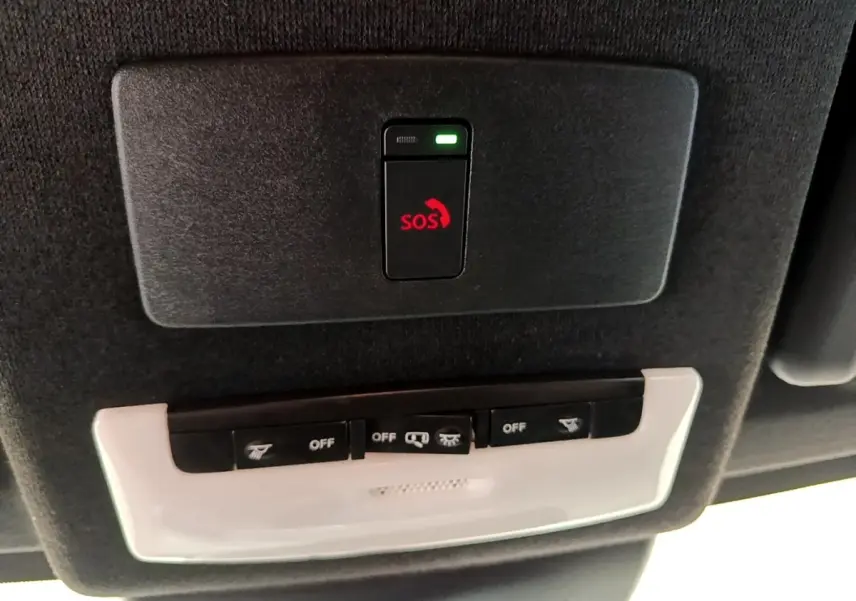 Vue intérieure du toit d’un Nissan Juke noir 2022, avec bouton d’appel d’urgence SOS et commandes d’éclairage.