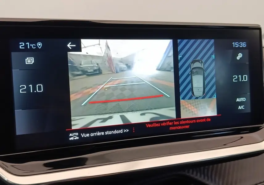 Écran tactile de la Peugeot 208 blanc montrant la caméra de recul et l’aide au stationnement arrière.
