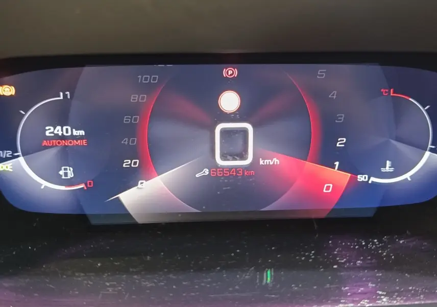 Affichage numérique du tableau de bord de la Peugeot 208 PureTech 100, montrant la vitesse, autonomie et température moteur.