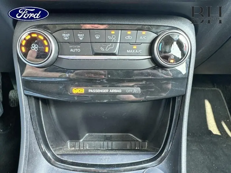 Vue rapprochée de la console centrale du Ford Puma 2024 avec commandes climatisation et témoin airbag passager allumé