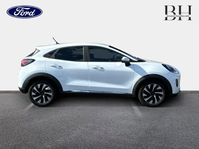 Profil droit du Ford Puma blanc Glacier 2024 avec jantes noires et vitres teintées sur fond clair.