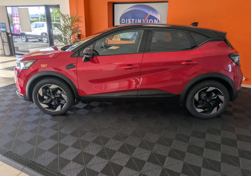 Profil côté gauche du Renault Captur E-Tech Full Hybrid 160 Techno rouge flamme avec toit noir et jantes alliage 18 pouces.