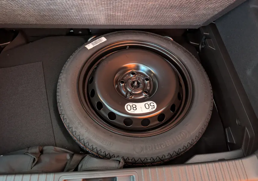 Roue de secours noire en acier dans le coffre d'un Renault Captur E-Tech Full Hybrid 2025.