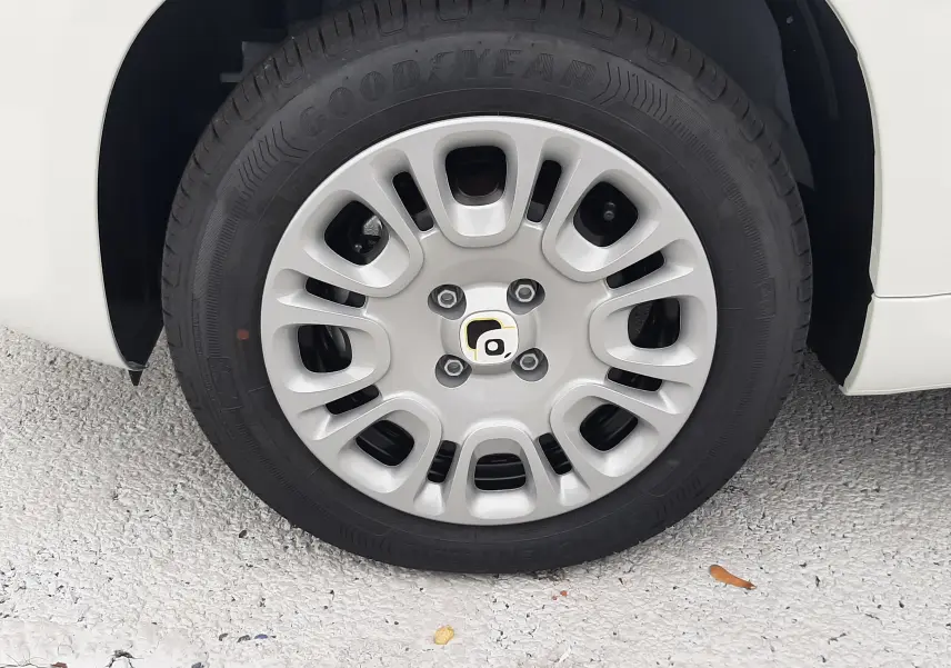 Gros plan sur la roue avant gauche d'une Fiat Panda blanc gelato avec jante en alliage et pneu Goodyear.