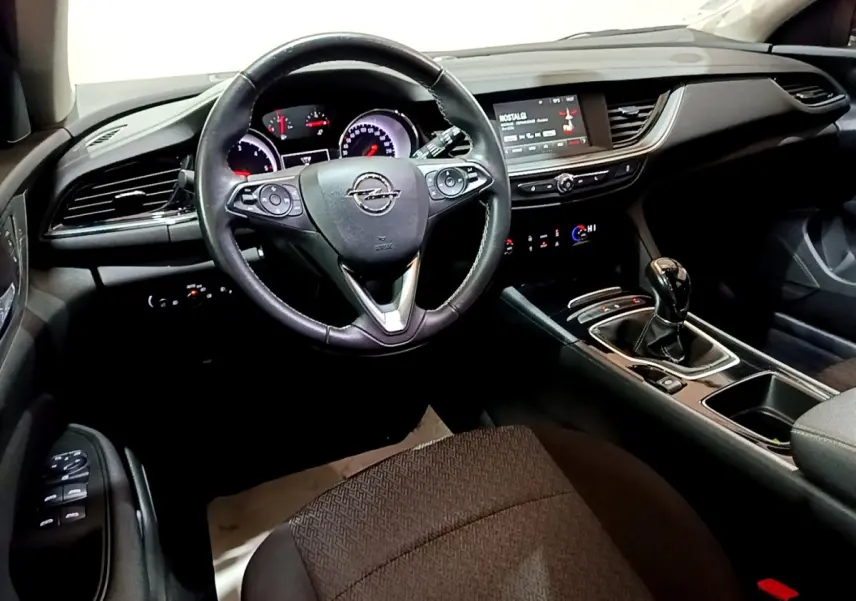 Vue intérieure de face du poste de conduite de l'Opel Insignia 2019 avec volant cuir noir et tableau de bord digital.