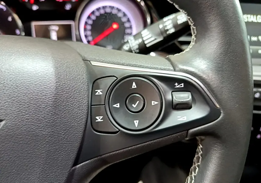 Gros plan sur les commandes du volant en cuir noir de l’Opel Insignia 2019, version Edition Business.