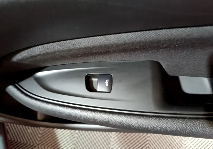 Gros plan sur le bouton de verrouillage centralisé dans la portière intérieure côté gauche d’une Opel Insignia rouge.