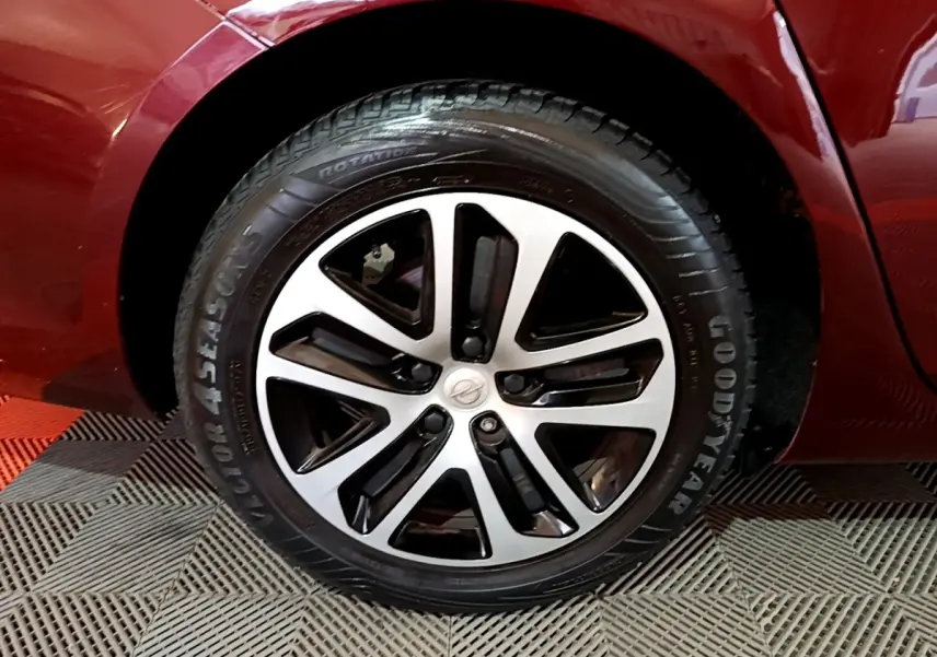 Gros plan sur la roue avant droite d’une Opel Insignia rouge, avec jante alliage bicolore et pneu Goodyear.