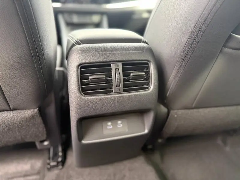 Vue rapprochée des aérateurs arrière et prises USB entre les sièges avant du Nissan Qashqai Hybrid e-POWER 2025 gris Argile.