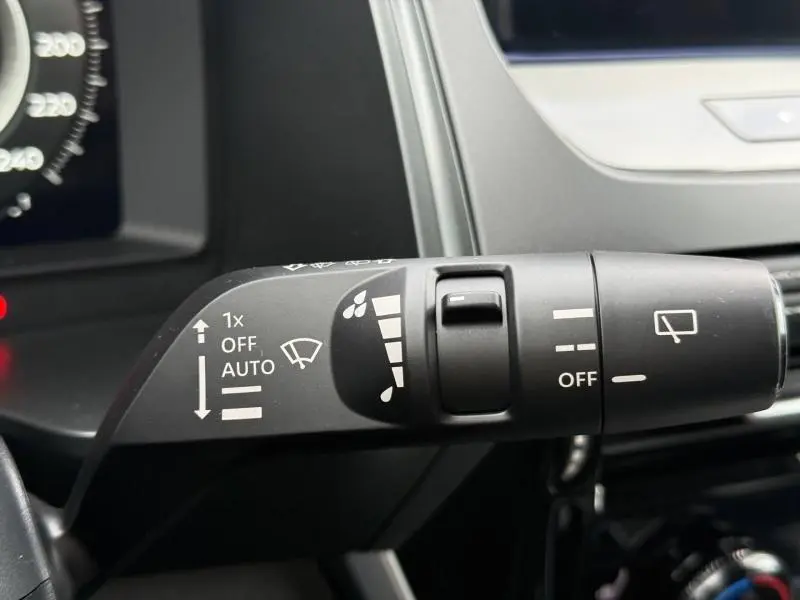 Gros plan sur la commande des essuie-glaces du Nissan Qashqai Hybrid e-POWER 2025, intérieur noir avec détails blancs.