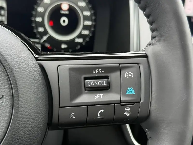 Gros plan sur les commandes au volant côté droit du Nissan Qashqai Hybrid e-POWER 2025, finition Gris Argile.