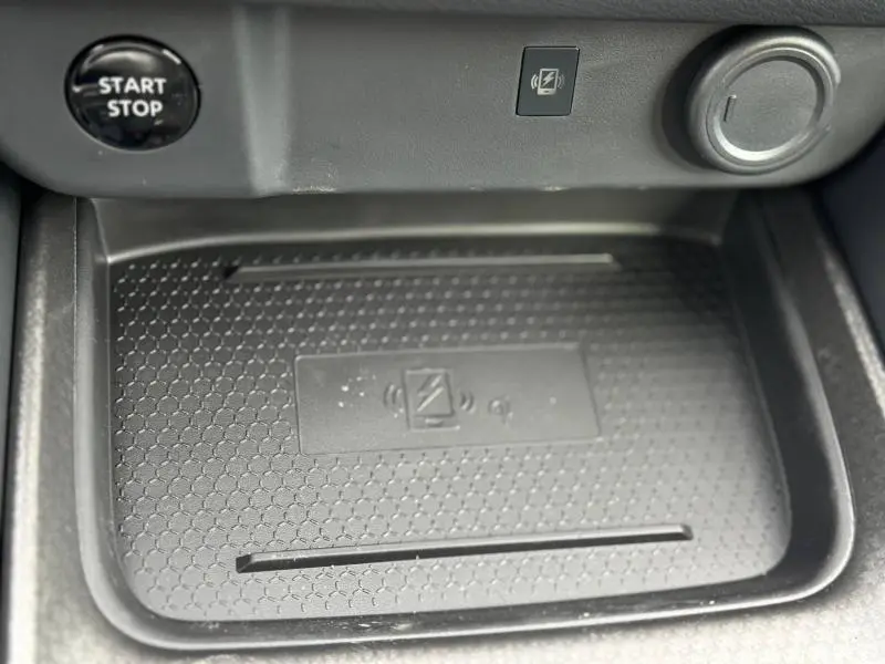 Gros plan sur la console centrale du Nissan Qashqai Hybrid e-POWER 2025, montrant le bouton Start/Stop et le chargeur sans fil noir.