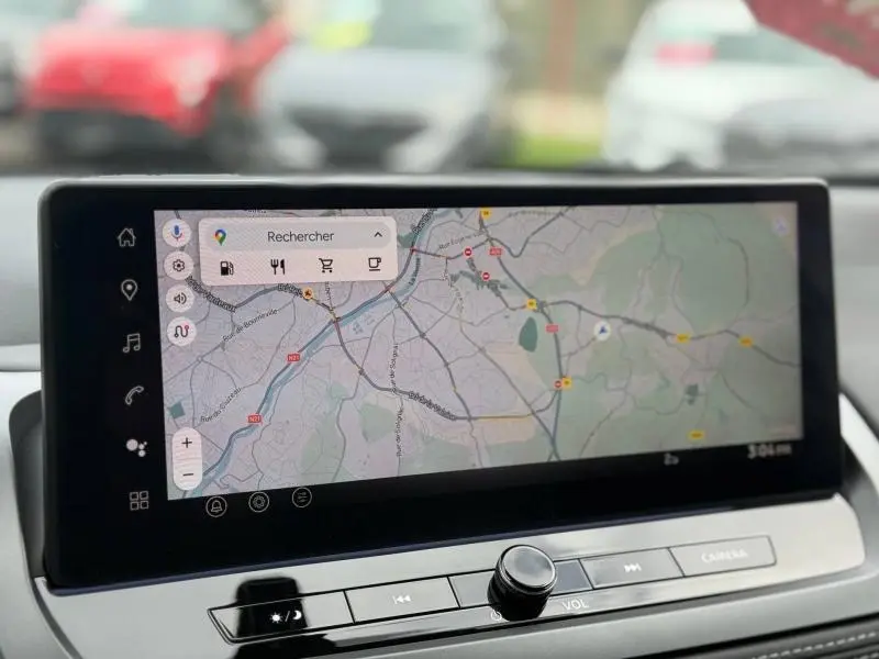 Écran tactile central du Nissan Qashqai Hybrid e-POWER 2025 affichant une carte de navigation, avec commandes en dessous.