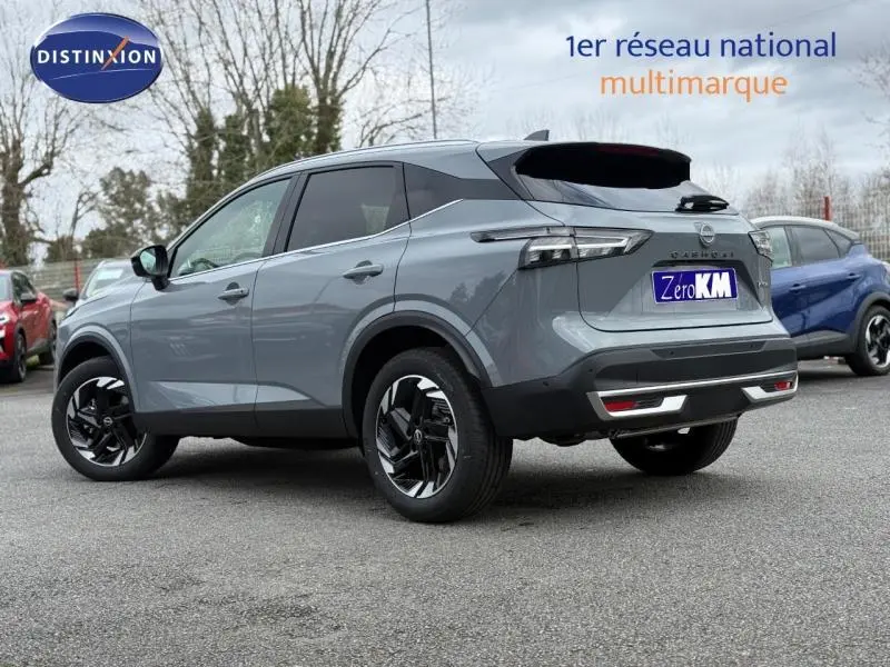 Nissan Qashqai Hybrid e-POWER 2025 en gris argile, vue 3/4 arrière droit avec jantes noires distinctives.