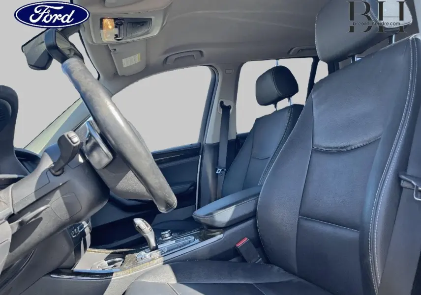 Intérieur avant droit d’un BMW X3 gris Mineralsilber, sièges cuir noirs et console centrale avec levier de vitesse cuir.