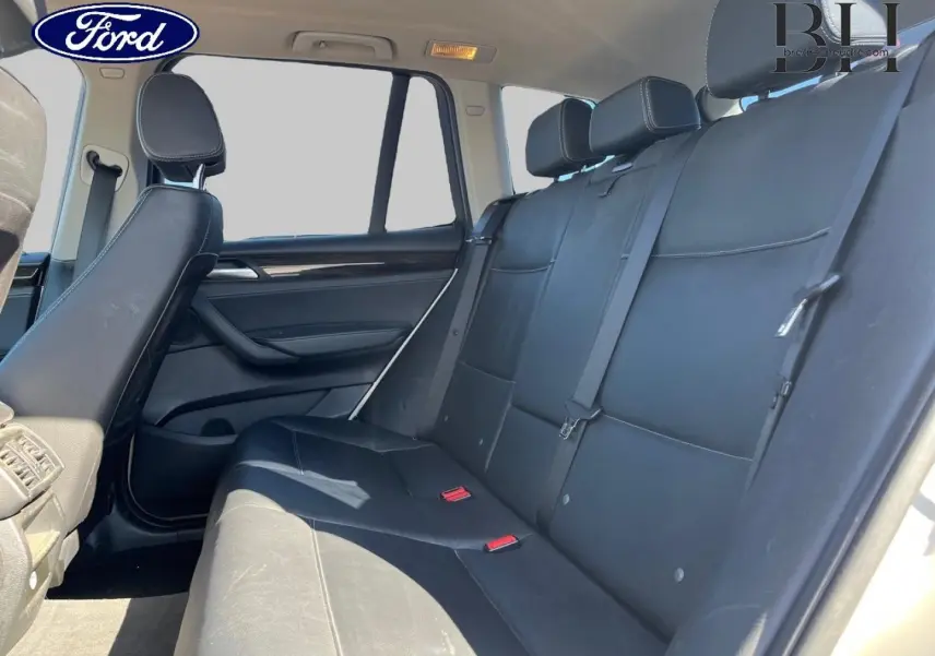 Vue latérale droite de la banquette arrière en cuir noir du BMW X3 Mineralsilber, avec appuis-tête et ceintures visibles.