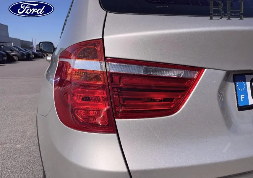 Feu arrière gauche en gros plan sur BMW X3 Mineralsilber vue 3/4 arrière, avec carrosserie argentée brillante.