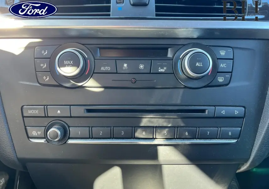 Panneau de commande central intérieur d'une BMW X3 Mineralsilber, avec réglages climatisation et radio visibles.