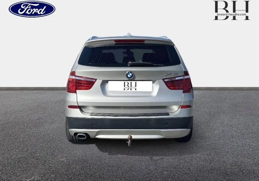 Vue arrière d'un BMW X3 Mineralsilber 2013 avec attelage et feux arrière rouges visibles.